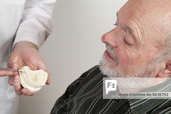 Patient  59  at the dentist  being shown a plaster model