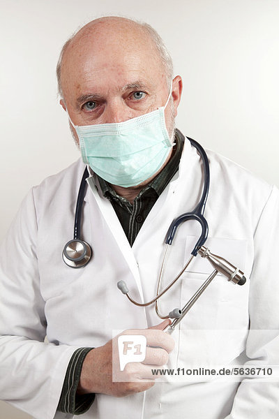 Älterer Mann  Arzt mit Mundschutz  Stethoskop und Reflexhammer