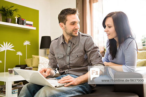 Young couple with laptop at home