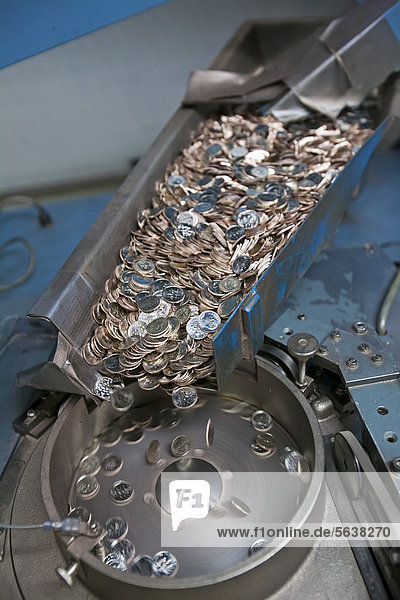 Production of coins at the United States Mint  finished dimes go through a counting machine before being packaged for distribution  Denver  Colorado  USA
