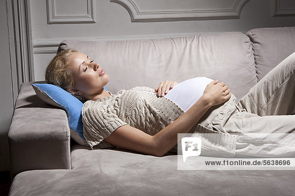 Schwangere Frau schläft auf dem Sofa