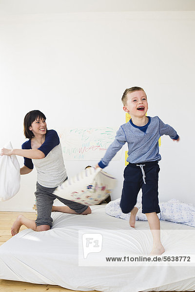 Mother and son having pillow fight