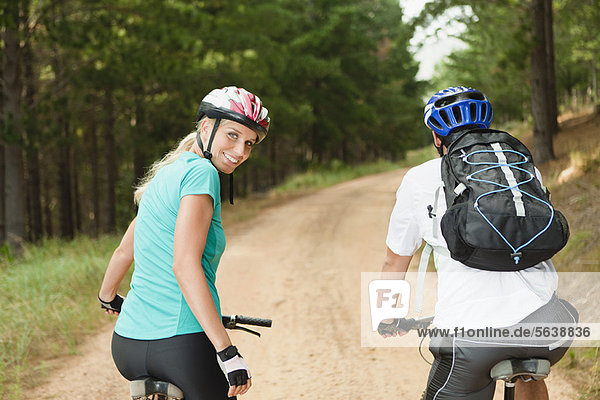 Couple mountain biking on dirt road