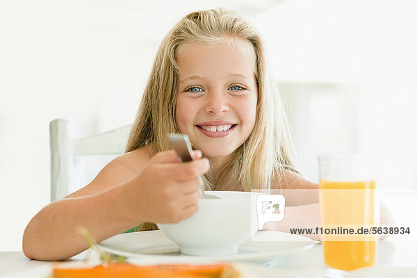 Mädchen essen Müsli am Frühstückstisch