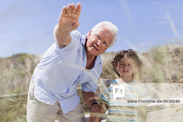 Older man and grandson standing outdoors