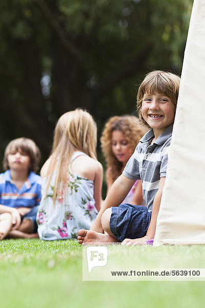Smiling boy sitting in tent outdoors