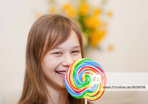 Smiling girl holding lollipop