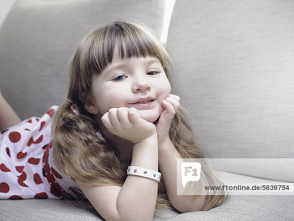 Smiling girl relaxing on sofa