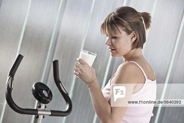 Woman drinking milk in home gym