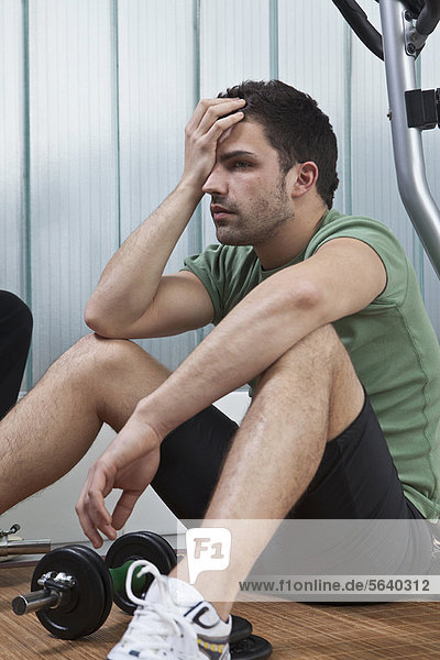Man sitting on floor in home gym