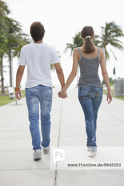 Young couple have s stroll hand in hand