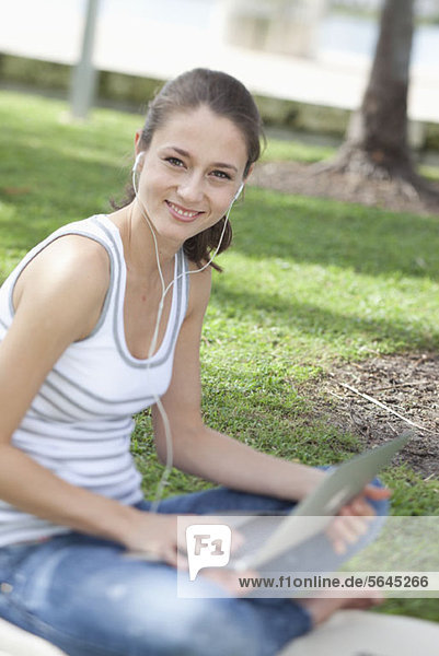 Happy girl using laptop outside