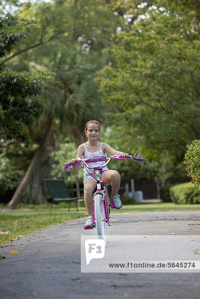 Mädchen mit dem Fahrrad durch den Park