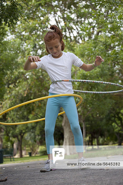 Girl with hula hoops in park