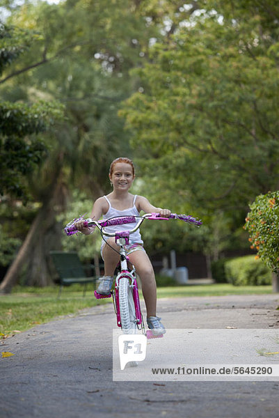 Mädchen mit dem Fahrrad durch den Park