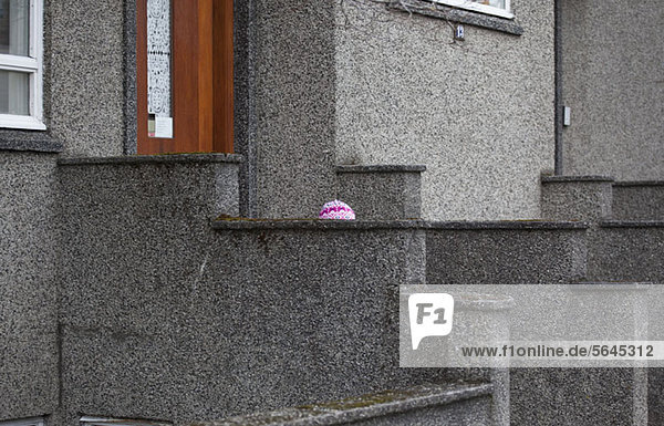 View of the knitted hat of a child in front of a building