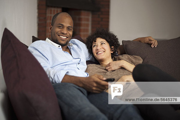 A happy laughing couple relaxing on a sofa together