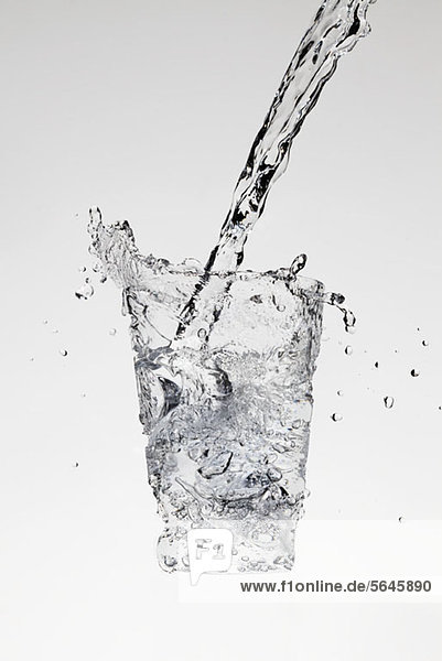 Wasser wird in Form eines Glases gegossen