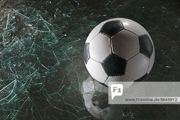 Ein Fußball auf zerbrochenem Glas