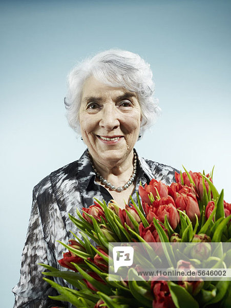 Eine ältere Frau  die einen Strauß Tulpen erhält.