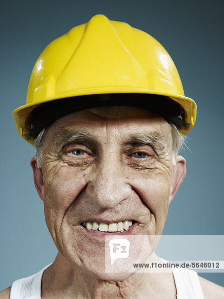 Kopfschuss eines älteren Mannes mit gelbem Schutzhelm