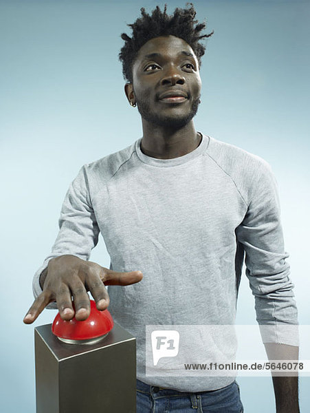 Ein angesagter junger Mann mit der Hand über einem roten Spielsummer