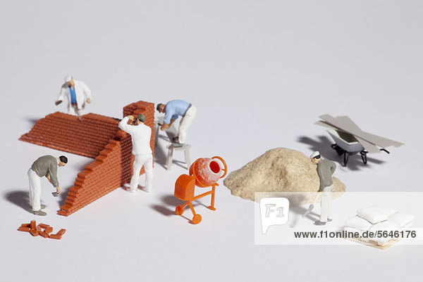 Miniaturmaurer beim Bau einer Ziegelwand