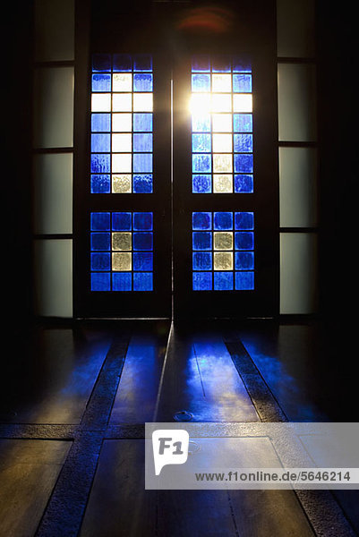 Blaue Farbe projiziert auf den Boden durch die Glasmalerei-Tür