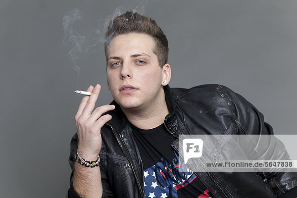 Junger Mann in Lederjacke raucht Zigarette  Portrait