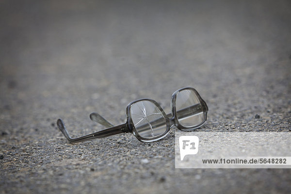 Alte zerbrochene Brille liegt auf der Straße