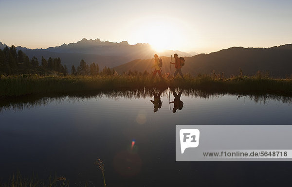 Austria  Salzburg  Couple walking near mountain lake at sunrise