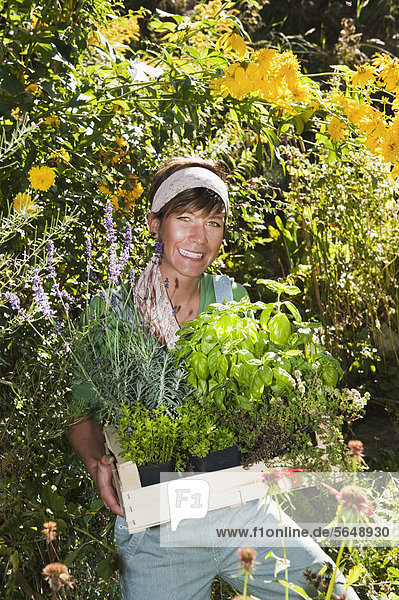 Österreich  Salzburg  Flachau  Junge Frau im Garten  lächelnd  Portrait