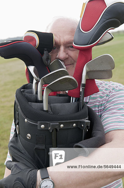 Germany  North Rhine Westphalia  Duesseldorf  Golfer with golf bag  portrait