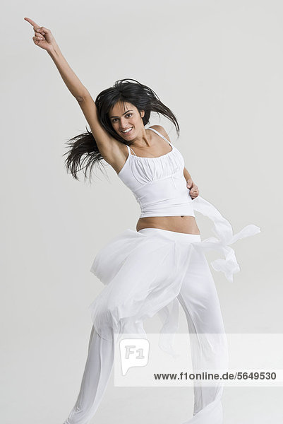 Junge Frau springend und tanzend  lächelnd  Portrait