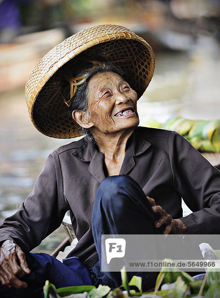 Lachende alte Frau mit Strohhut am schwimmenden Markt  Damnoen Saduak  Thailand  Südostasien  Asien