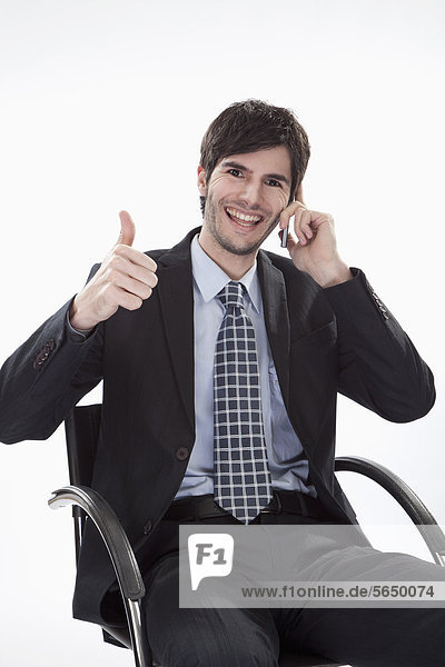 Businessman using cell phone  smiling  portrait