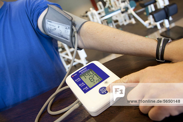 Pulsmessung und Blutdruckmessung vor dem Training in einem Fitness-Studio  Regensburg  Bayern  Deutschland  Europa