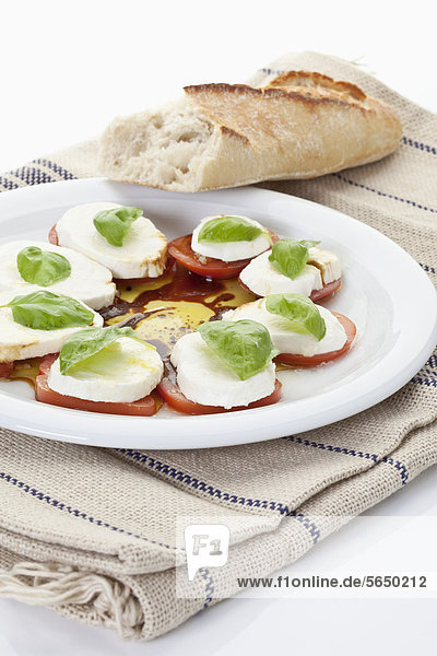 Mozzarella  Brot  Tomatenscheiben mit Basilikum auf Serviette