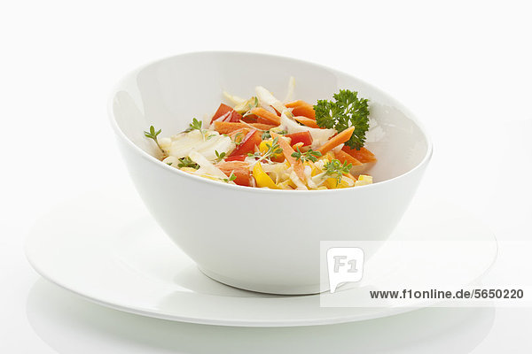 Salat in Schale mit Teller auf weißem Grund
