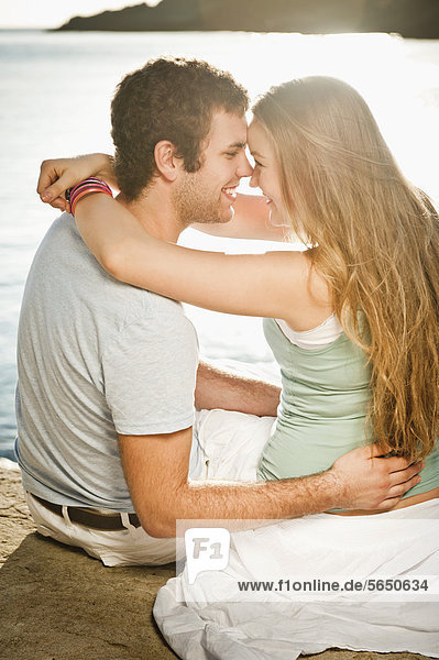 Spanien,  Mallorca,  Paar am Strand sitzend,  lächelnd
