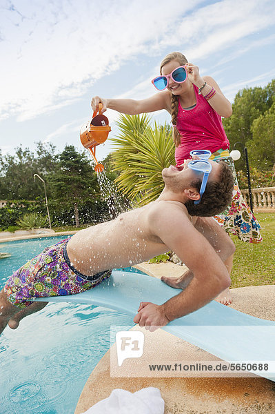 Spain  Mallorca  Couple playing on swimming pool