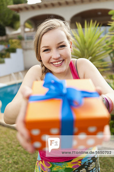 Spanien  Mallorca  Teenager Mädchen mit Geschenkbox  lächelnd  Portrait