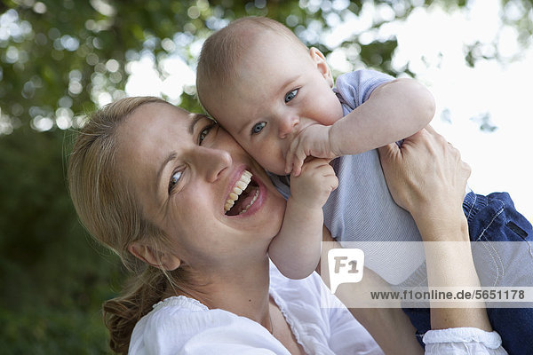 Mutter und kleiner Junge im Garten  lächelnd