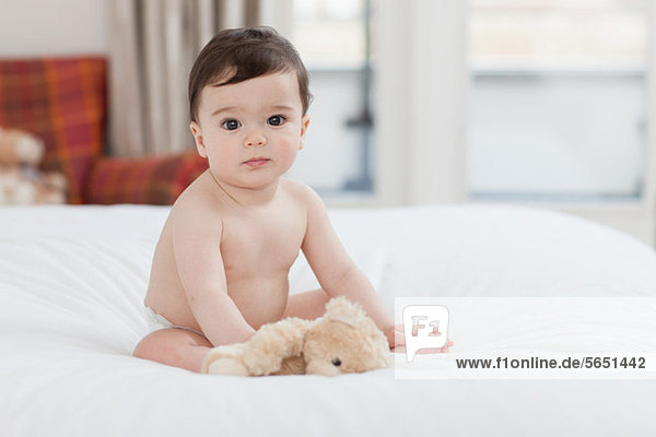 Portrait of a baby boy sitting on bed