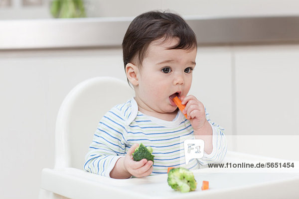 Baby boy eating healthy vegetables