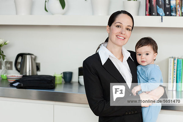 Businesswoman holding baby son