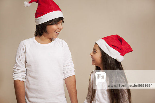 Kinder mit Weihnachtsmütze  lächelnd
