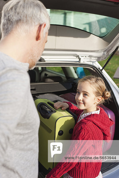 Deutschland  Leipzig  Vater und Tochter beim Verladen von Gepäck ins Auto