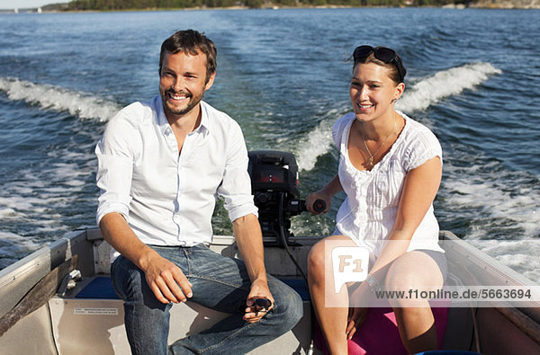 Happy couple enjoying while sitting on motorboat