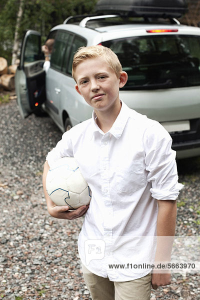 Porträt eines vorpubertären Kindes mit Fußball